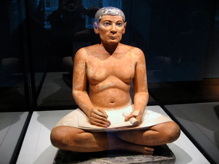 O Escriba Sentado. 4ª ou 5ª Dinastia do Egito, c. 2600 - 2350 aC, de Saqqara, em exposição no Louvre, Paris.